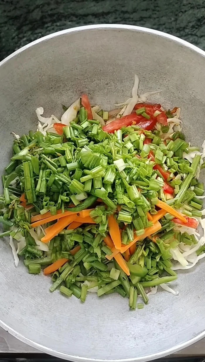 Add green chilies and spring onions. Mix well and sauté until vegetables are cooked through.