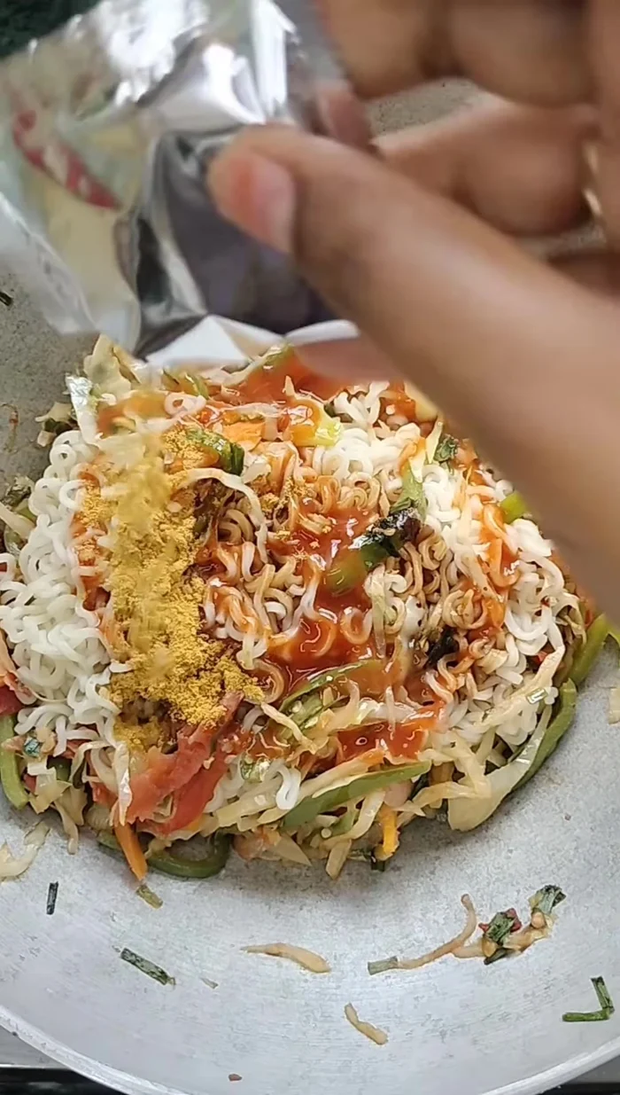 Add boiled noodles, soy sauce, Maggi masala, salt, and chili sauce. Mix well to combine.