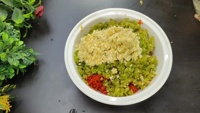In a bowl, combine the chopped chilies, ginger, garlic, salt, sugar powder, asafoetida powder, white sesame seeds, and vinegar. Mix well.