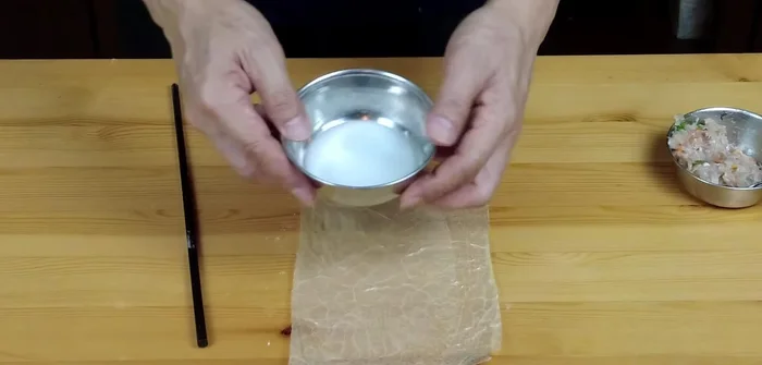 Wrap the filling: Place a portion of the filling in the center of each bean curd sheet. Brush the edges with cornstarch slurry to help seal. Roll up tightly, sealing the ends (408.479).