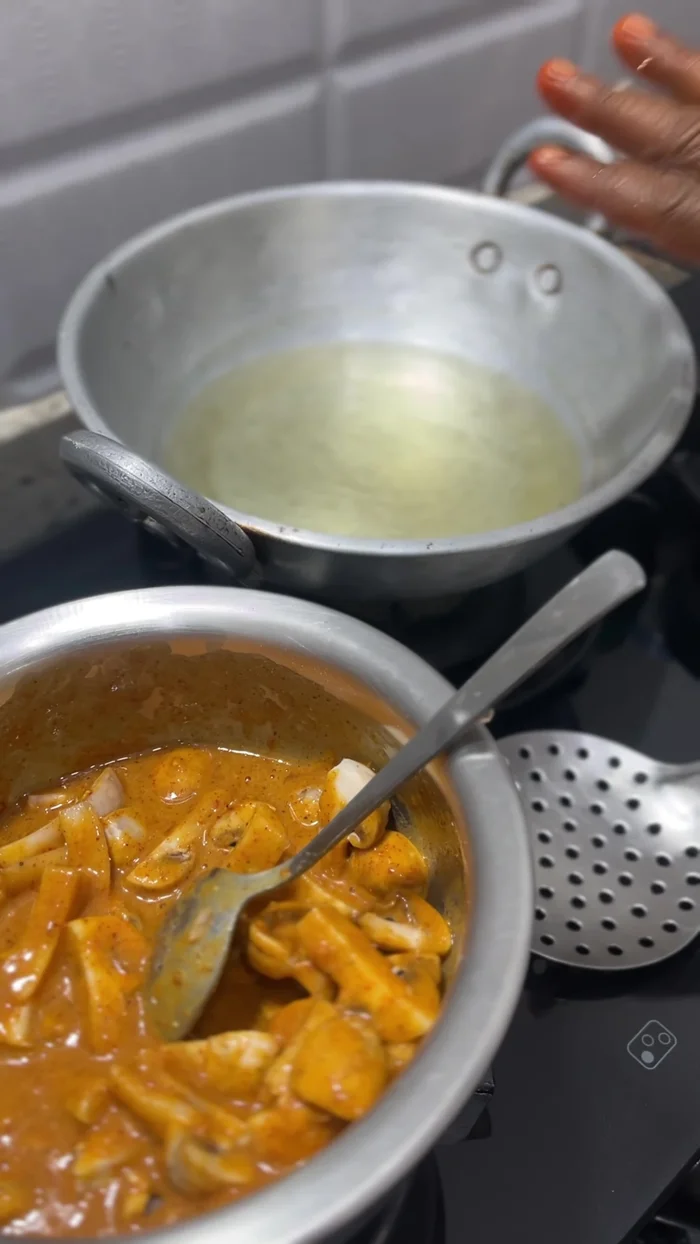 Carefully add the battered mushrooms to the hot oil, frying them one by one until golden brown and crispy.