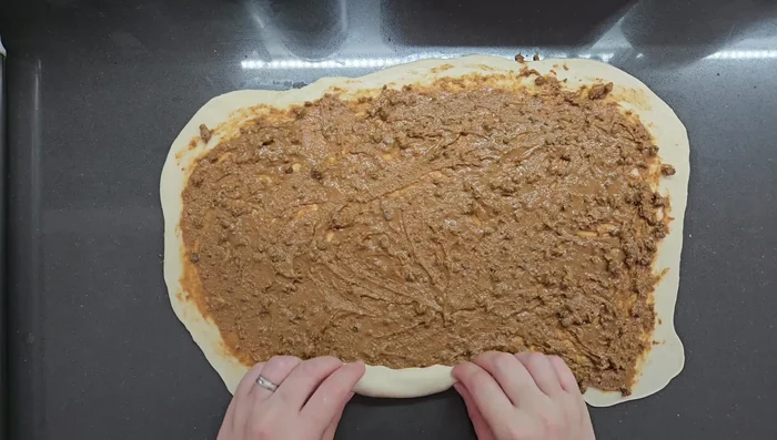Roll and shape the buns: Roll up the dough like a Swiss roll, then fold into thirds and flatten. Roll again to create layers (354.199s).