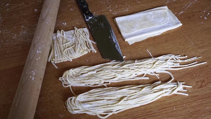 Continue stretching until the dough forms thin, springy noodles. (Alternative: use the knife-cut technique to slice a block of dough into noodles)