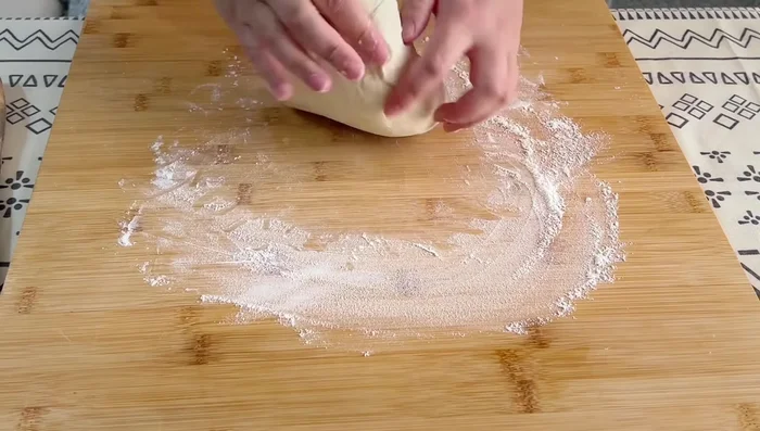 Prepare the bread: Deflate the dough, knead until smooth. Divide into 10 portions. Roll each portion into a flat circle. Apply a thin layer of oil crisp in the center. Fold the edges to create a pocket, ensuring no air is trapped. Gently press the sides and roll from the center, alternating between forward and backward movements to create an oval shape.