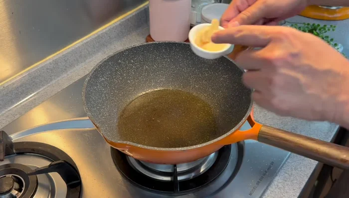 Add sliced ginger to the pan and fry until fragrant over medium-low heat.