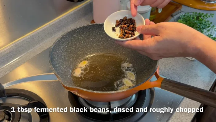Add rinsed and chopped fermented black beans and fry until fragrant.