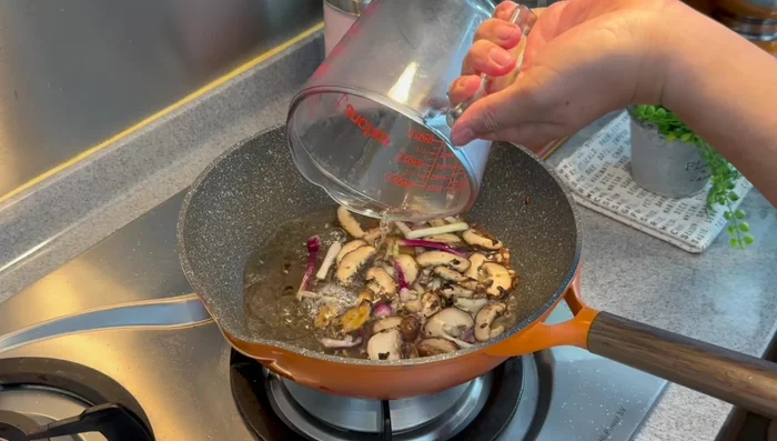 Increase heat slightly. Add water, oyster sauce, light soy sauce, sugar, and dark soy sauce. Mix well.
