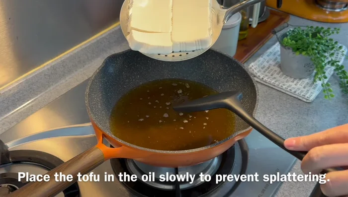 Deep fry the tofu in hot oil over medium heat until golden brown and crispy (about 6-7 minutes). Don't stir or touch them initially.