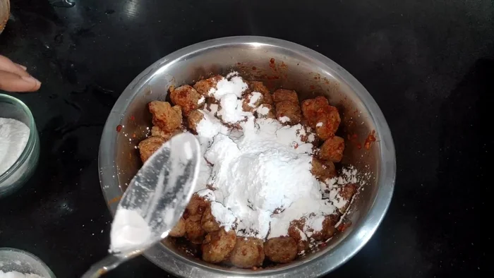 Add corn flour and rice flour to the mixture and mix well. This will give the Manchurian a crispy exterior and juicy interior.