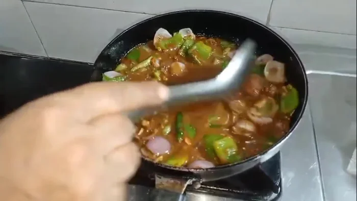 Pour the gravy into the wok with the onions and capsicum. Cook for four minutes. Add salt to taste.