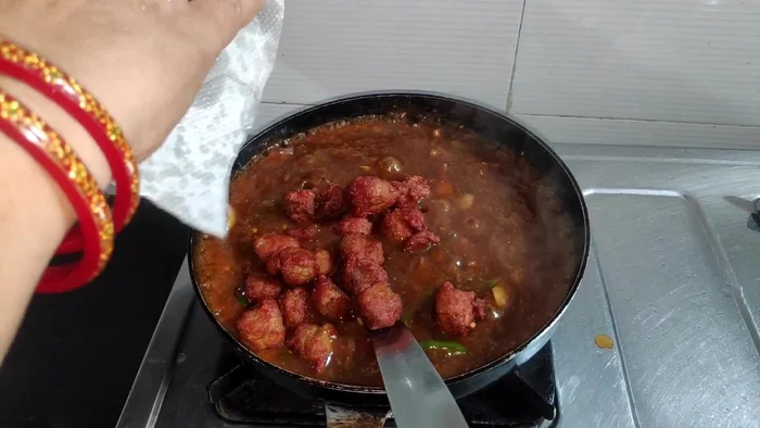 Add the fried soya Manchurian balls to the gravy and mix well.