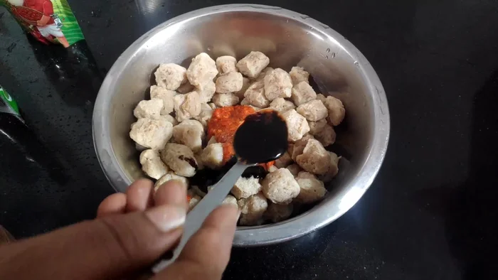 Mix the drained soya chunks with garlic paste, red chilli paste, soy sauce, green chilli sauce, and ketchup. Add salt to taste.
