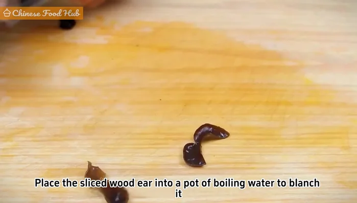 Blanch the wood ear strips in boiling water until the water boils again. Remove and set aside.
