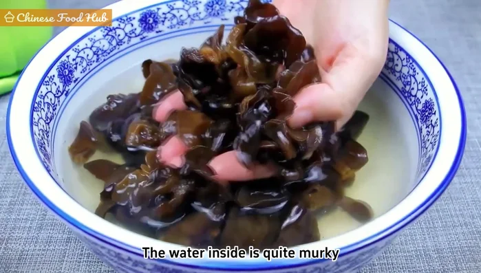 Rinse the rehydrated wood ear mushrooms thoroughly to remove any dirt and impurities.