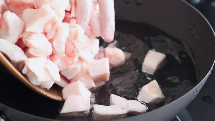 Place the cut pork fat into a pot. (This is where the music likely plays while the lard renders.)