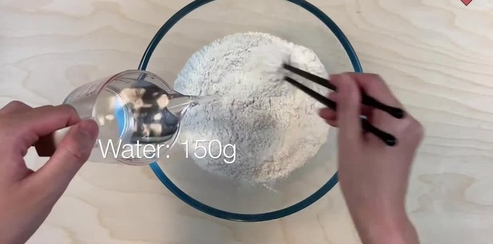 Prepare the dough by mixing flour and water. (This step is implied by the music and the later rolling of the dough)
