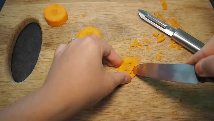 Once carved, you can optionally add garnishes to your carrot pumpkins to enhance their appearance.