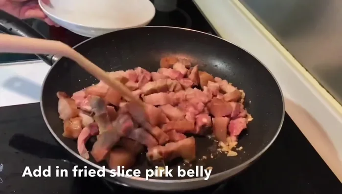 Stir-fry until the sauce thickens and coats the pork belly evenly.