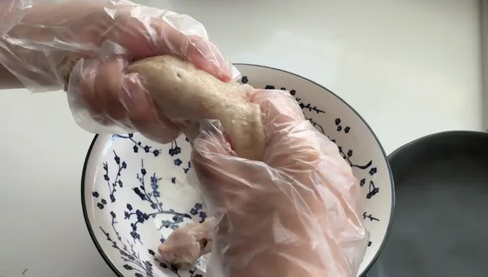 Shred the cooled chicken into thin strips.