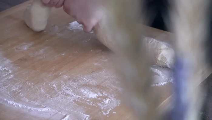 Divide the dough into 8-10 even pieces. Fold each piece inward to create a smooth, round shape.