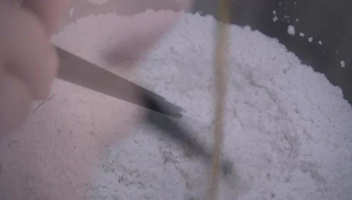 Gently pour in the warm water while stirring with chopsticks, adding a little at a time until there's no loose powder.