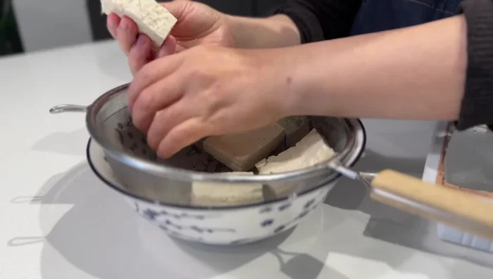 Cut 200g of firm tofu into small pieces and place them in a strainer for an hour to drain excess water. Pat dry with a paper towel.
