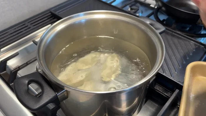 Cook the dumplings: Bring a large pot of water to a boil. Add dumplings, stir gently to prevent sticking. Keep heat high initially. After the first boil, lower heat to medium and add 1/3 cup water. Repeat with 1/2 cup water, then 1 cup water, each time after it boils. Dumplings are usually cooked after the third boil.