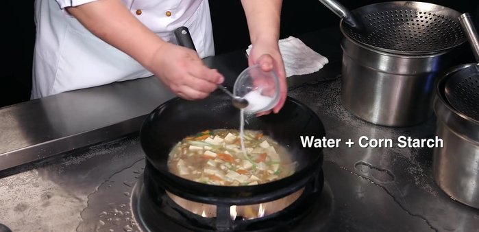 Cooking and possibly adding more ingredients.