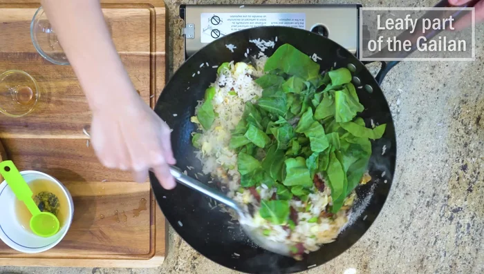 Add the Gai Lan leaves and scallions. Stir-fry until wilted.