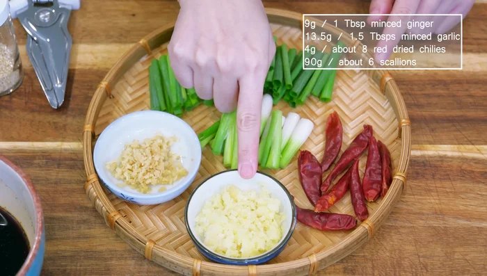 Prepare aromatics: Mince ginger and garlic, and prepare dried chilies and scallions.