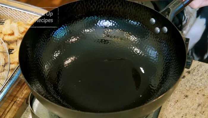Pour out most of the oil, leaving 1 1/2 tsp. Add garlic, ginger, chilies, and white parts of scallions; stir-fry for 2-3 minutes.