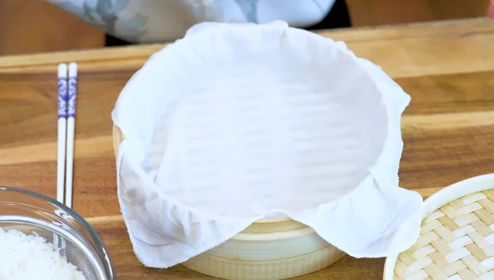 Steam glutinous rice for 30 minutes over medium heat after water boils. Place rice on a damp cheesecloth in the steamer.