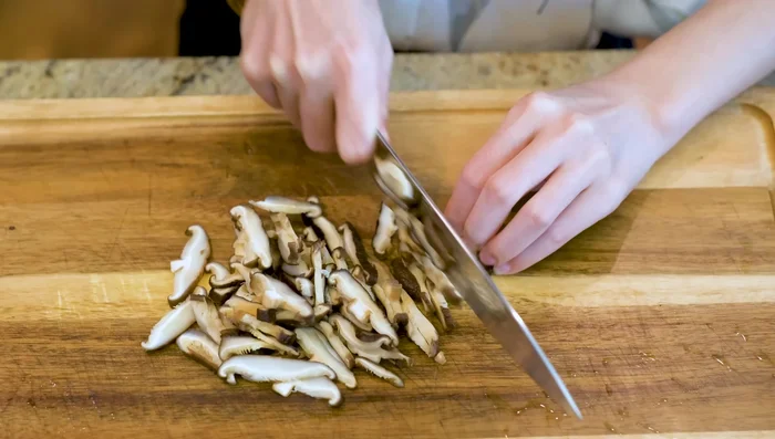 While rice steams, prepare other ingredients: slice mushrooms thinly, remove and rinse shrimp, and slice pork belly thinly.