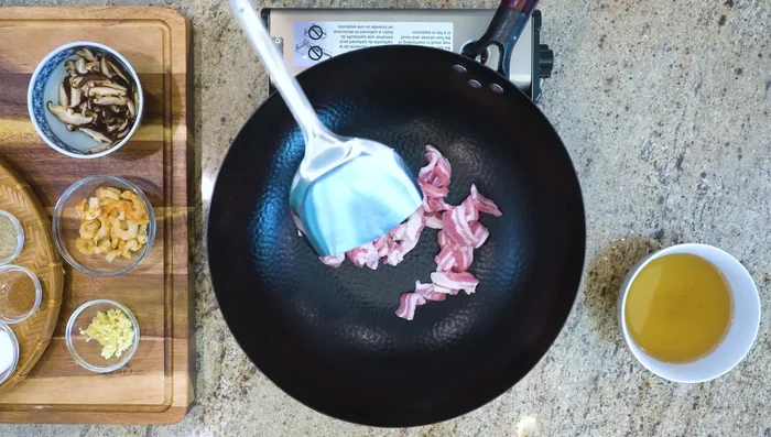 Render fat from pork belly in a wok over medium-low heat (about 5 minutes) until golden brown.