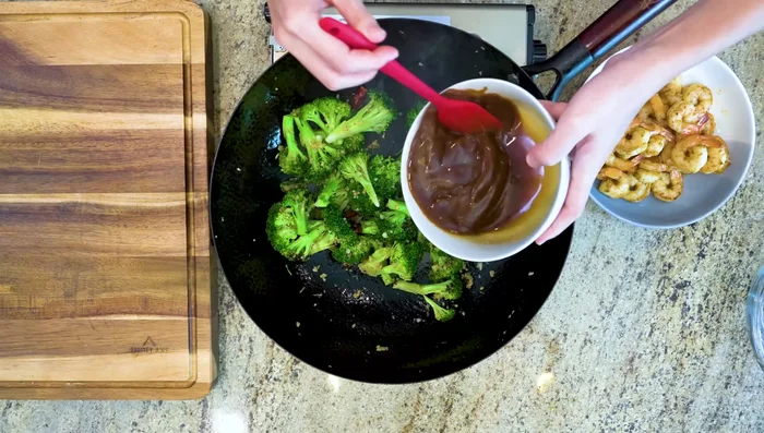 Pour in the sauce and return the shrimp to the wok. Toss until thickened.