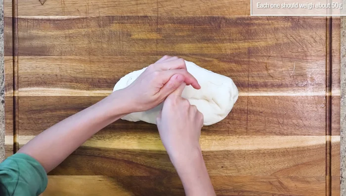 Punch down the proofed dough, divide into 12 pieces, roll into balls, then flatten and roll into oval sheets (1/3 inch thick). Brush half with oil, fold, and place on parchment paper.