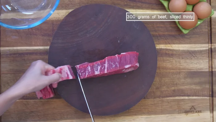 Remove silver skin from New York strip steak. Cut into 1/8 inch thick slices.