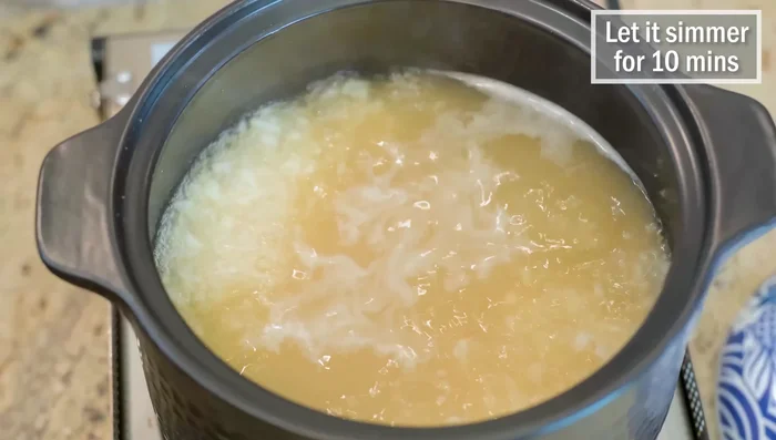 Reduce heat to medium-low, simmer for 10 minutes, using chopsticks to prop the lid slightly to prevent overflow.