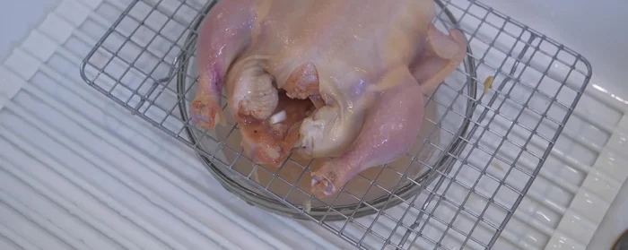 Blanch the chicken: Remove the hen from the marinade. Boil water and pour over the hen to blanch, stretching the skin and making it smooth. (47.8)