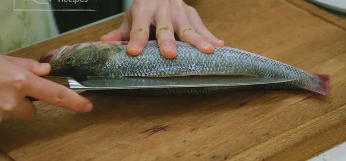 Slice the fish along the backbone on both sides to ensure even cooking. Optionally, slice the fillets a few times.