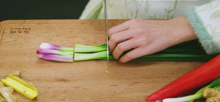 Prepare the aromatic bed: Cut ginger and scallions into strips and julienne them with red chili. Soak in water for 10 minutes to curve naturally.