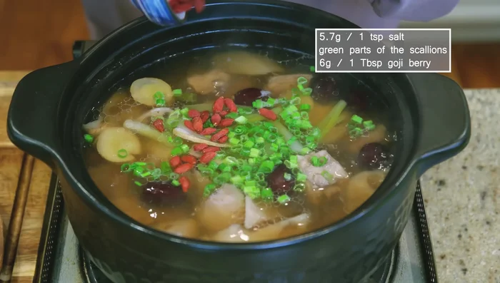 Before serving, add salt to taste and garnish with diced scallions and goji berries.