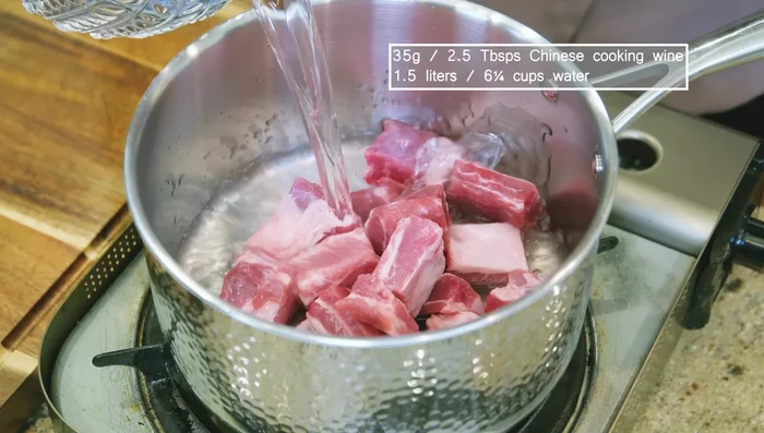 Add ribs, cooking wine, and water to a pot. Partially cover and bring to a boil.