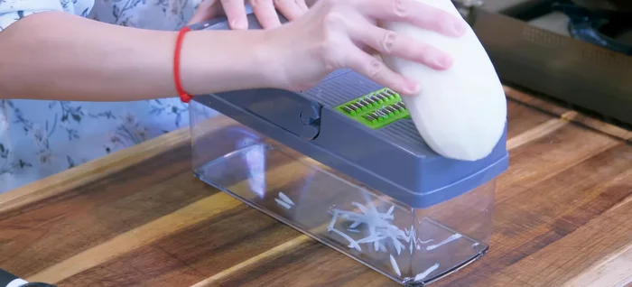 Peel and shred the daikon radish using a vegetable grater. Toss with 1 teaspoon of salt and set aside for 20 minutes to draw out moisture.