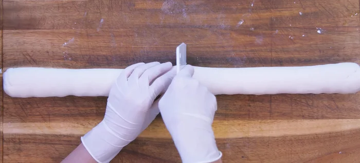 Roll the dough into a log, divide into 12 pieces, and cover to prevent drying.