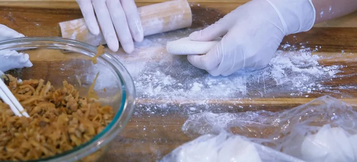 Flatten each dough piece into a circle, roll out with rolling pin. Fill with about 50g of the prepared filling and wrap into dumplings.