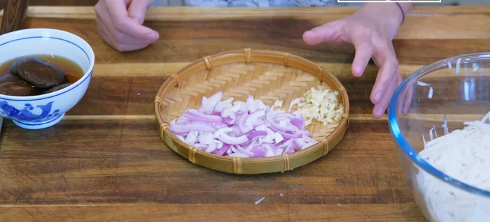 While the radish sits, prepare the other ingredients: thinly slice shallots, finely dice garlic and rehydrated shiitake mushrooms.