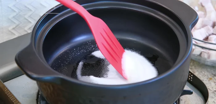 Caramelize sugar: Preheat clay pot, add oil and sugar. Stir over medium-low heat until caramelized.