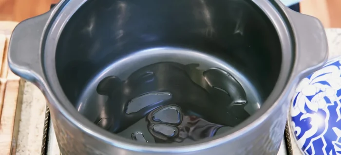 Preheat clay pot, add oil and sugar, caramelize until foamy bubbles appear.