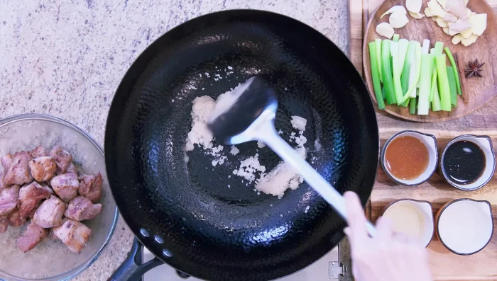 Add sugar to the wok and stir over medium-low heat to caramelize (3 minutes).